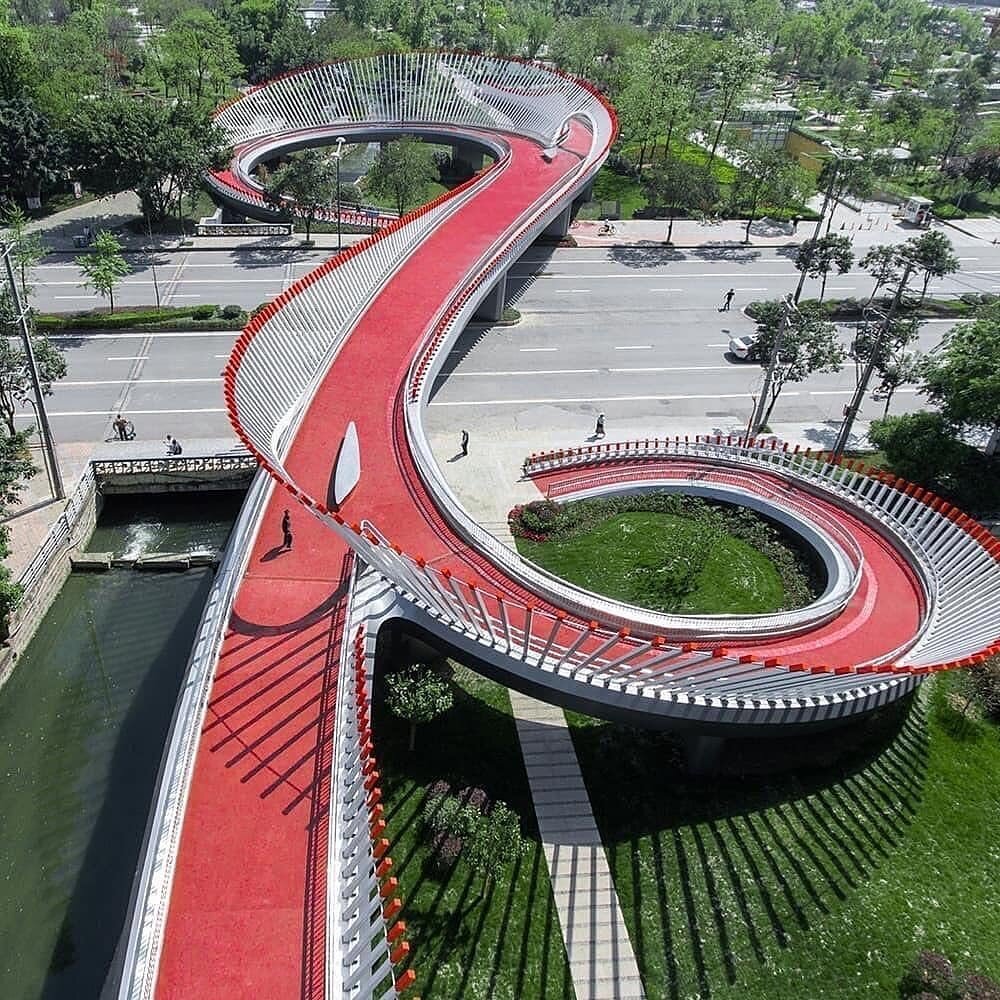 Основной канал: https://t.me/citysight
Пешеходный мост, связывающий парк с городской зоной. Обьединяет пешеходную спиральную лестницу и пандус для велодорожки. Писать по нему нечего, просто классный дизайн, создателям плюсик в карму✔️.  Поскольку это китайцы, у них любая форма обязана что-нибудь символизировать, поэтому мост похож на руйи - это  такая китайская декоративная фигня, которая имеет S-образную форму, обычно сделана из нефрита и символизирует удачу. Так и назвали😜