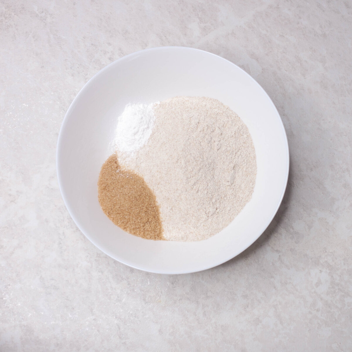 В миске смешиваем муку, сахар и разрыхлитель. Хорошо объединяем венчиком.