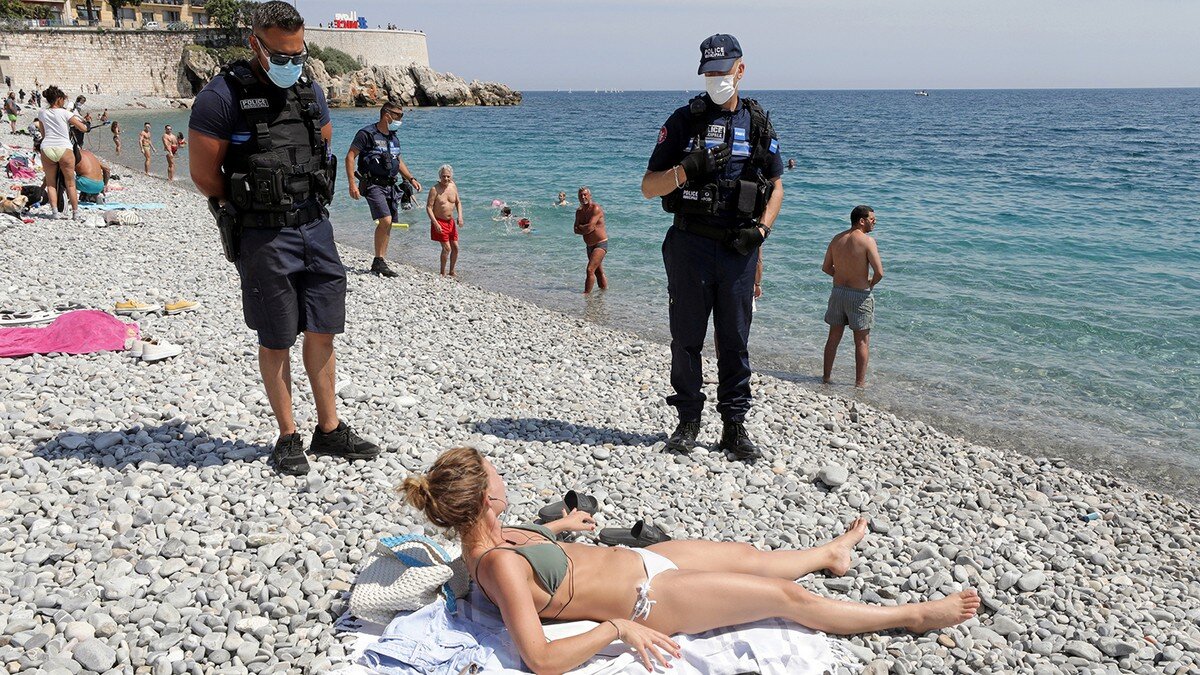 Полицейские штрафуют женщину на пляже за отсутствие маски