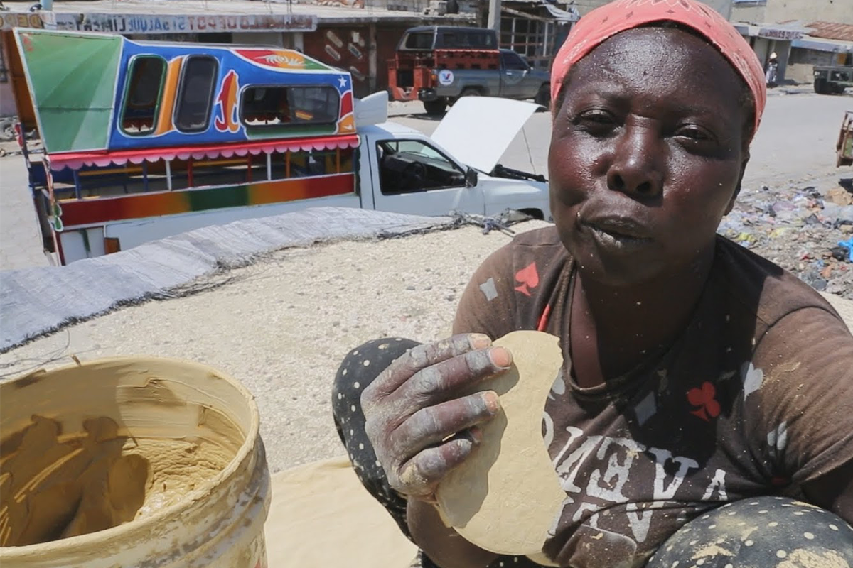 Гаитянка ест грязевую лепёшку. Бедные местные жители вынуждены их есть из-за бедности