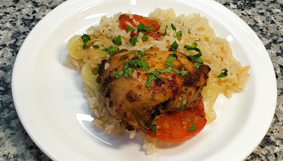 Куриные бедра, запечённые с помидорами и рисом, - яркое, ароматное и невероятно сочное блюдо. Куриное мясо по этому рецепту получается очень мягким и вкусным. 
Ингредиенты:
куриные бедра - 950 гр.
рис пропаренный - 200 гр.
помидоры - 350 гр.
лук - 180 гр.
соус Сацебели - 60 мл.
томат сушеный - 1 ч.л.
чеснок сушеный - 1 ч.л.
черный перец - 1 ч.л.
соль, сахар по вкусу
масло сливочное - 20 гр.
зелень, вода

1. Рис промыть, залить горячей кипяченной водой. Оставить в сторону.
2. Приготовить маринад из специй и соуса Сацебели. Замариновать промытые и обсушенные куриные бедра.Оставить на час мариноваться.
3. Нарезать лук кольцами, обильно посолить. Помидоры нарезать толстыми кольцами.
4. С риса слить воду. Выложить его в форму для запекания, разровнять.
5. Поверх риса выложить сливочное масло и лук.
6. На лук выложить помидоры, обильно посолить.
7. На помидоры выложить куриные бедра. Налить горячую кипяченную воду так, чтобы она закрыла рис.
8. Закрыть форму фольгой.
9. Запекать в разогретой до 180 градусов духовке 90 минут.
10. После снять фольгу, смазать бедра соусом Сацебели и отправить на 15 минут в духовку для зарумянивания. 