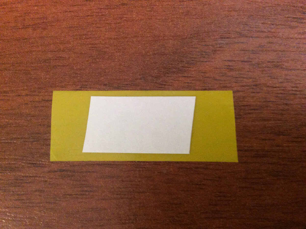 Небольшой кусочек белой бумаги посередине изоленты