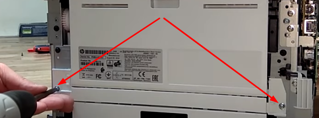 Откручиваем два винта на задней стенке принтера и снимаем ее вместе с узлом печати