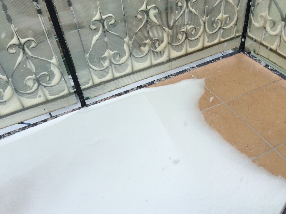 На балконе образовался безобразный, довольно глубокий сугроб. Одно хорошо - кованное ограждение выглядит гораздо эффектнее, когда каждый завиток украшен снежной шапочкой
