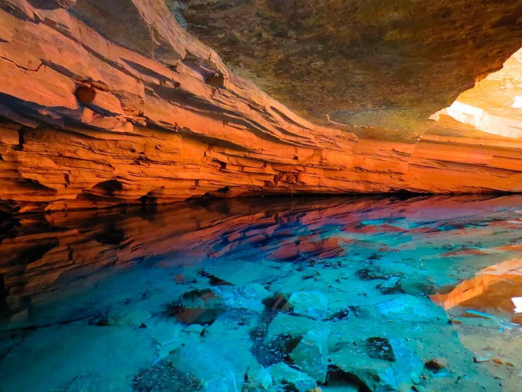 )На территории бразильского национального парка Шапада-Диамантина, расположенного в штате Баия, находится удивительный памятник природы - небольшое, но удивительно красивое озеро, которое получило название Зачарованный колодец. Озеро расположено а пещере глубиной около восьмидесяти метров, спустившись к совершенно прозрачной воде можно ясно рассмотреть древние столы деревьев, многие сотни лет покоящиеся на его дне, на глубине около сорока метров. 
Главное чудо, связанное с озером, происходит каждое утро с половины одиннадцатого до полудня. В это время солнечный свет проникает в пещеру и падает на поверхность озера. Преломляя лучи солнца, Зачарованный Колодец, словно по волшебству наполняется нежно сапфировым сиянием, отбрасывая мерцающие лазурные блики на стены пещеры.