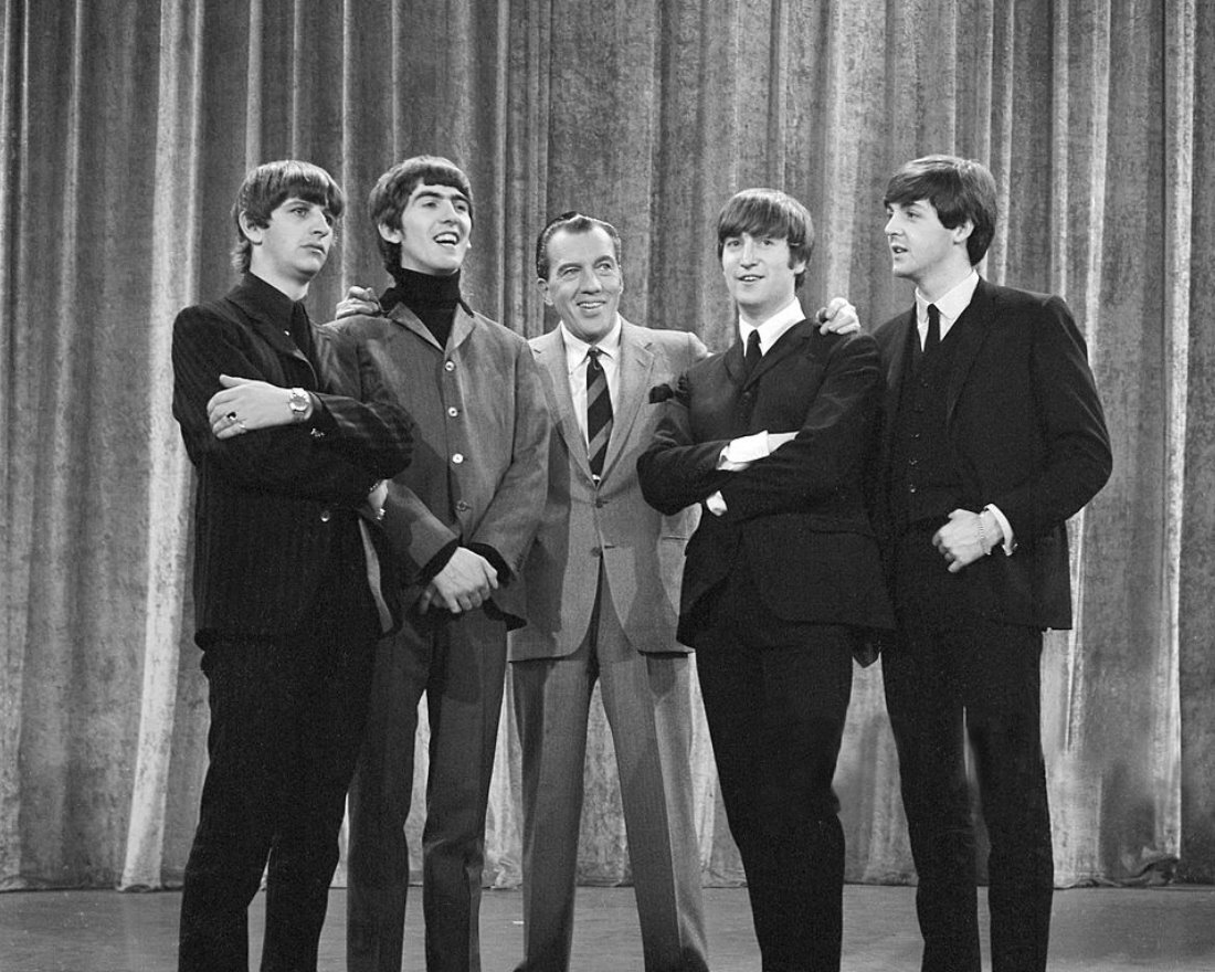 1. Фотография The Beatles с Эдом Салливаном с момента их первого появления в телевизионной программе американского варьете Салливана в феврале 1964 года. Слева: Ринго Старр, Джордж Харрисон, Эд Салливан, Джон Леннон, Пол Маккартни