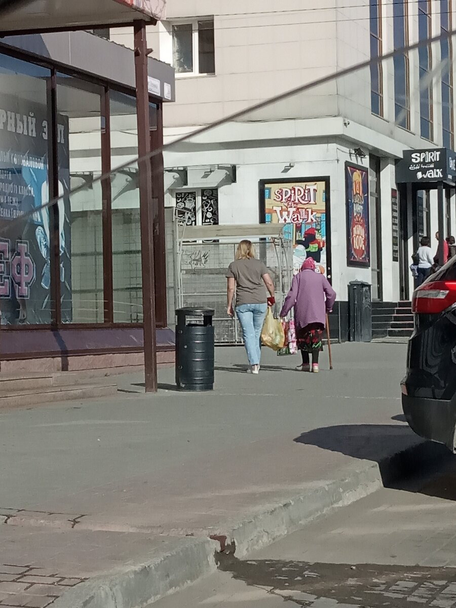 Женщина помогает с пакетом.