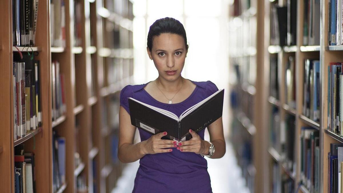    Девушка с книгой в библиотеке:Pixabay