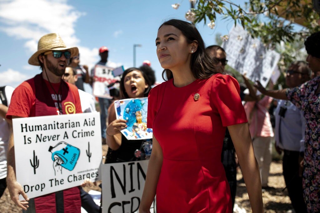 Представитель Нью-Йорка Александрия Окасио-Кортес проходит через демонстрантов в понедельник в городе Клинт, штат Техас.