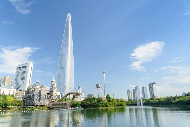 Пятая по высоте башня Lotte World Tower (554м.) называют "жемчужиной Кореи". Башня получила имя в честь ее застройщика и владельца, Lotte Group, как и соседний культурно-оздоровительный комплекс. Оба объекта являются важными туристическими направлениями Сеула.
Светлая цветовая палитра стеклянных навесных стен и мягкая кривизна здания вдохновлены корейской керамикой и резко контрастируют с городом. Здание включает в себя все многофункциональные помещения, которые мы привыкли ожидать от сверхвысоких башен, такие как офисы, коммерческие помещения и модный отель, но также в нем есть и новый тип функционального пространства, характерного для Кореи: "офисные помещения" Officetel. Это что-то вроде квартир-студий, сочетающих жилое и рабочее пространство. 