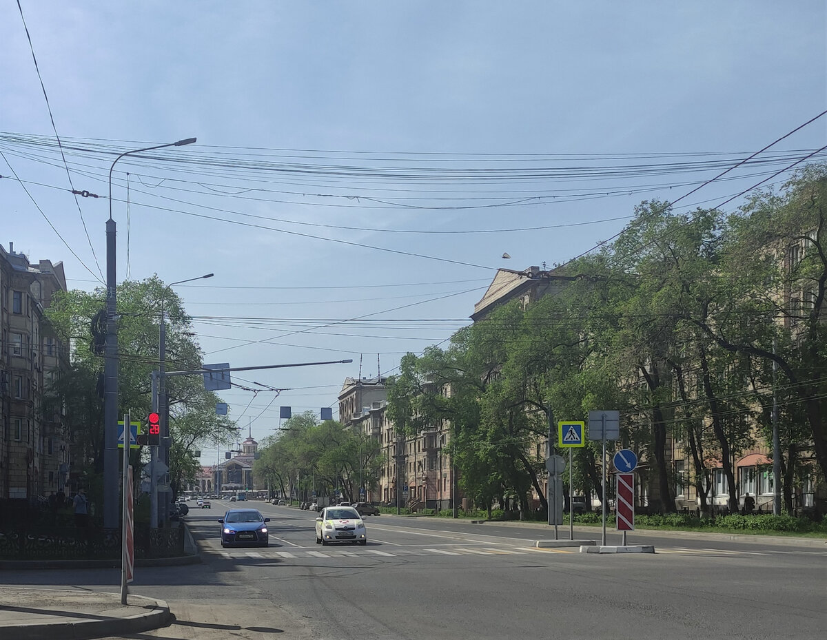 Начало проспекта Металлургов. Вдалеке вокзал. Вдоль этого участка дороги без разрывов  построены жилые дома чередующейся высоты, симметричные, как отражения 