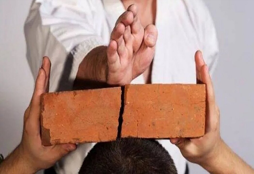 Разбитый кирпич. Белый человечек разбивает стену. Кусок кирпича. Разбить кирпичики. Разбивание кирпичей.