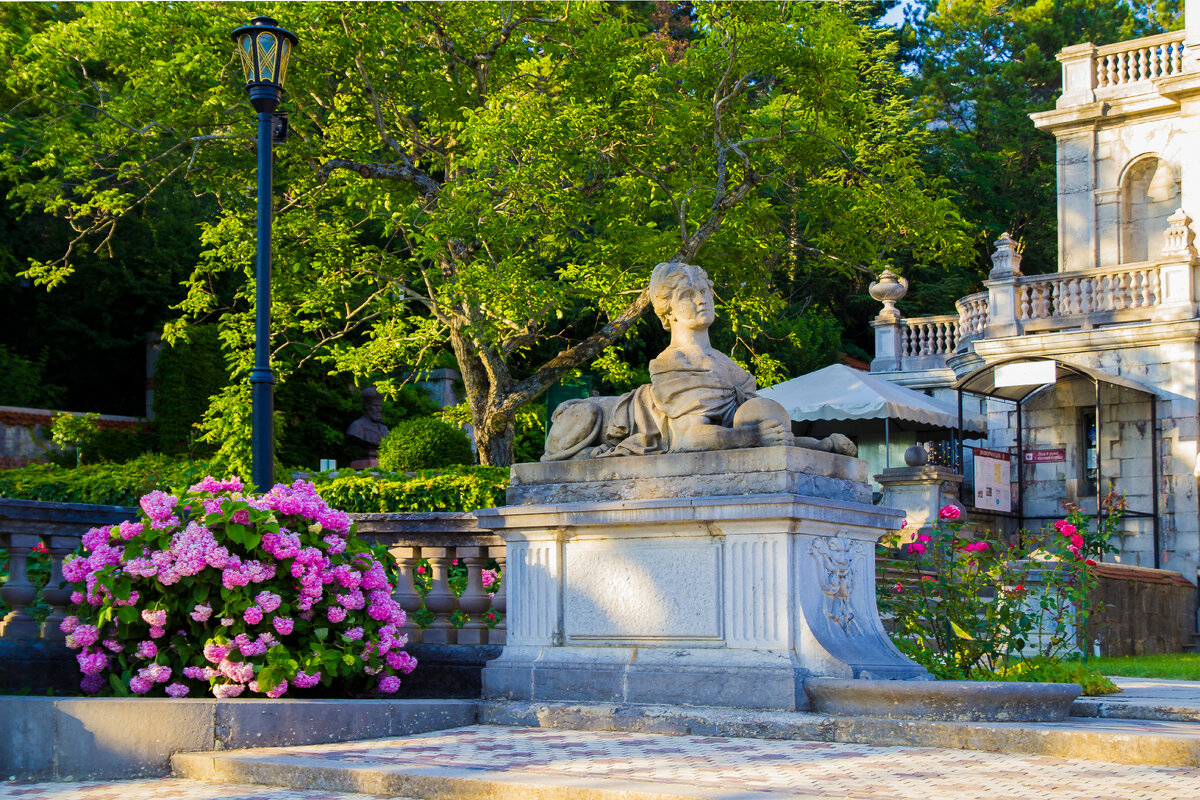 скульптура сфинкса, женщины-льва слева от здания