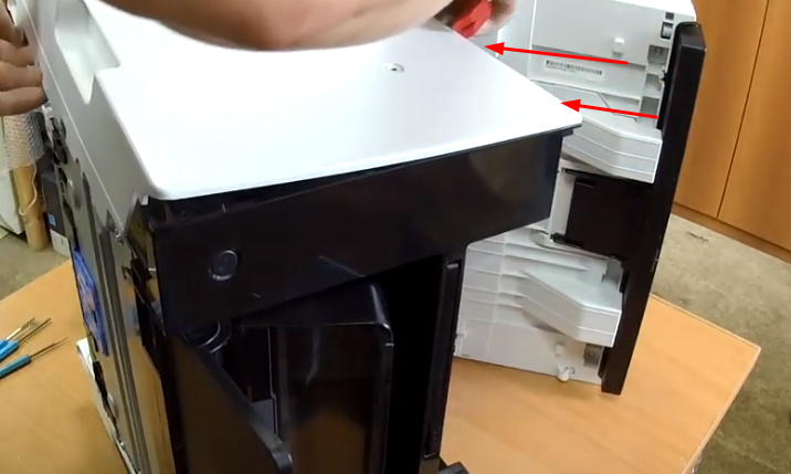 Фото 20. Лопаточкой для съема корпуса снимаем другую боковую крышку, открывая защелки с задней стороны аппарата