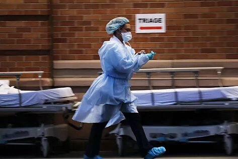 Врач заканчивает надевать защитный костюм в нью-йоркской больнице