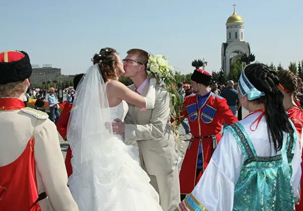 Так или иначе, этот день испокон веков был на Руси одним из самых радостных в году. Помимо катания яиц, с ним связано множество забав и обрядов — от закликания весны до "вешних смотрин", в которых участвовали только девушки. Они выбирали приглянувшегося им парня, а затем "выкликивали" для себя семейное счастье с ним. Слова, произносимые ими, тоже причудливо сочетали народные заговоры с православными молитвами:"Замыкаю я им, тем золотым ключом, доброго молодца на многие годы, на долгие весны, на веки веченские заклятьем тайным нерушимым. Аминь!"А те, кто уже обрел свою вторую половину, на Красную горку венчались. Сейчас эта традиция рассматривается как сугубо народная, однако возникла она из-за особенностей церковного устава."Таинство венчания не совершается в сплошные (непостные) недели и в дни поста. Так вот, в храмах перестают венчать, начиная с Мясопустной седмицы, и не венчают в течение всего Великого поста и на Светлой седмице. Фомино воскресенье — первый день за девять недель, когда это таинство дозволяется совершать", — объясняет отец Макарий.© РИА Новости / Владимир ФедоренкоМолодожены во время гуляний накануне церковного праздника Красная горка на Поклонной гореПосле Красной горки венчают в любой день, кроме среды, пятницы и праздника Вознесения, вплоть до дня Пресвятой Троицы (в 2020-м — 7 июня). А затем — опять перерыв, на сплошную неделю и Петров пост, который длится до 12 июля.В этом году, правда, все по-другому. Из-за эпидемии коронавируса и массовой самоизоляции храмы более чем в половине регионов России закрыты для прихожан. Поэтому в Русской православной церкви посоветовали отложить венчание.