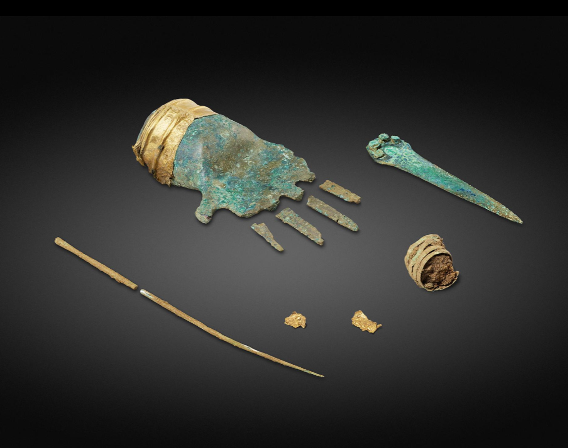 Бронзовая рука с золотой манжетой была найдена в захоронении мужчины, которому 3500 лет, вместе с бронзовой булавкой, используемой для крепления плаща, фрагментами из золотой манжеты, бронзовым спиральным орнаментом для волос и кинжал