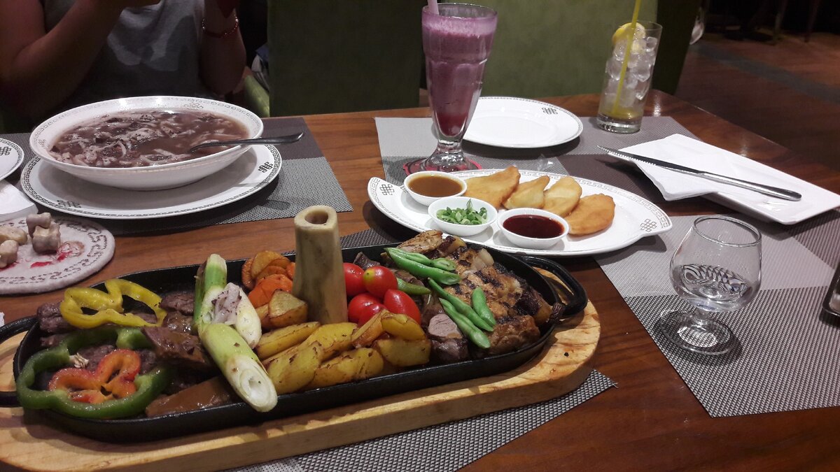 Монгольский хорхог на переднем плане. На заднем плане пироги хушуры и  суп хар шул. 