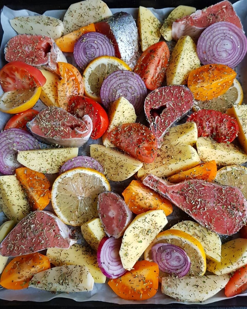 Готовить легко и просто.  Всё помыть, почистить, порезать и переложить на противень. Далее посолить, поперчить, добавить приправу для рыбы (у меня в этот раз были "Итальянские травы"). Обратите внимание, нужно быть осторожными с лимоном, не переборщите. Я добавляла только половину одного лимона на довольно большой противень, не выжимая его, просто порезала на кружочки . Как-то было дело использовала целиком, это было что-то😅 Пришлось самой всё есть😜Так что, осторожнее😃 При высокой температуре лимон выделяет очень много сока. Можно его не добавлять совсем либо полить соком лимона готовые кусочки рыбы. Запекала я при 200 градусах 30-35 минут в режиме верх-вниз. Приятного вам аппетита🌺