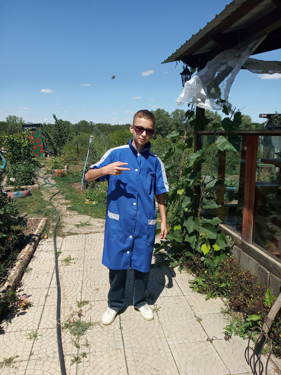 Здесь мой внук подрос и экипирован в бабушкин халат рабочий  для работы по скашиванию травы на тропинках триммером.