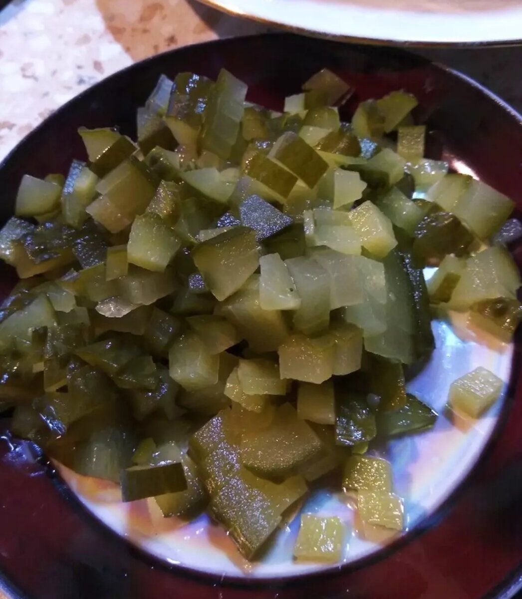 Огурец порезать кубиками. Шпроты размять вилкой.