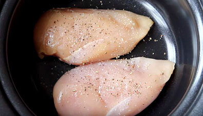 Куриную грудку тщательно промойте проточной водой и уложите на дно чаши мультиварки. Затем обильно посолите мясо и приперчите черным молотым перцем.