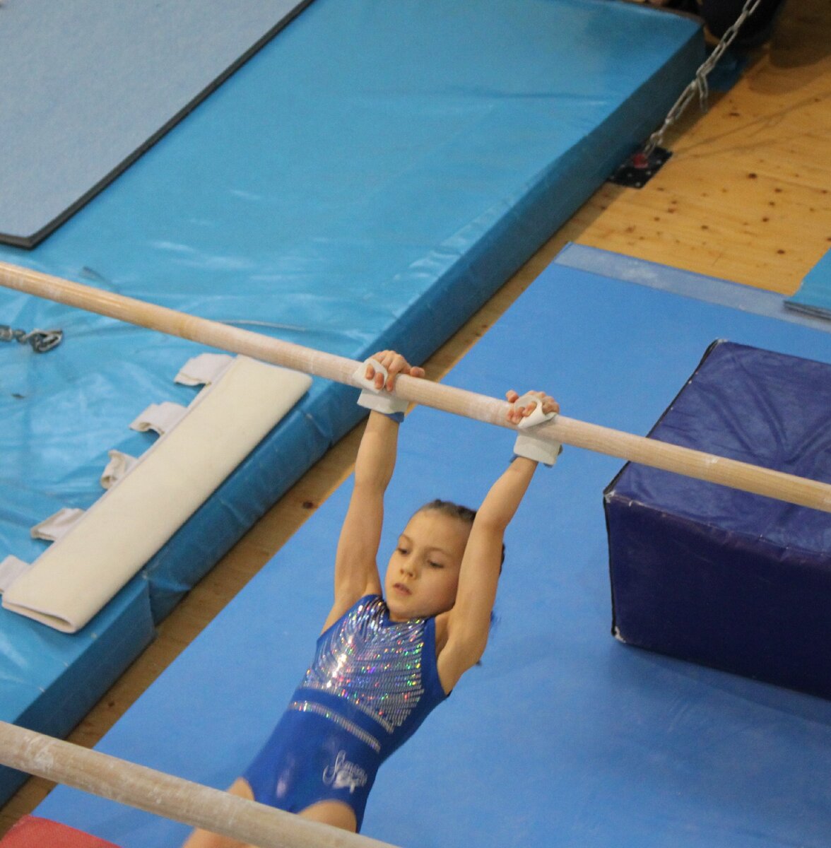 Моя дочь на брусьях в своих первых накладках. Личное фото.