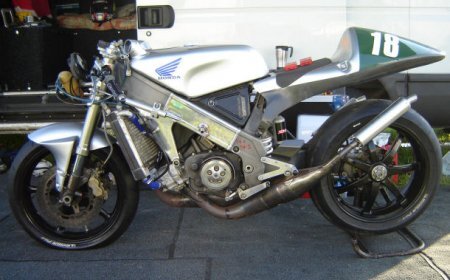 Устройство выхлопной системы
Выхлоп - система выпуска мотоцикла, надсадный вой спортивного японского рядника, неторопливое тарахтенье рядной британской двойки… Вот какие ассоциации возникают у обычного человека при словах "выхлопная система". Конструкторы и инженеры видят все немного по-другому, с суровой технической стороны. Мы не будем забираться в глубокие дебри, а просто составим представление, как работает "выдох" наших мотоциклов, причем постараемся сделать это максимально интересно.Теория, теория…Основные задачи, которые ставятся перед системой выпуска - отводить выходящие из камеры сгорания газы, охлаждать их и снижать уровень шума. Представьте, что было бы, если бы горячий выхлоп вылетал из цилиндра прямо в атмосферу! Само собой, передняя шина на пару с крылом расплавилась бы, а уровень издаваемого двигателем шума стал бы просто невыносим (ради интереса, попробуйте снять выпускную систему и завести мотор. Посмотрим, сколько продержится ваш нежный слух). Кроме того, если в выхлопе осталось немного несгоревшего топлива, то оно бы эффектно сгорало при контакте с кислородом воздуха. Поэтому выпускная система отводит отработавшие газы в "хвостовую" часть мотоцикла, охлаждая их и устраняя нежелательные тенденции к сгоранию в атмосфере.Еще одна задачи системы выпуска - использование пульсаций давления, образующихся на каждом рабочем такте. Это делается для улучшения очистки и наполнения камеры сгорания.Обычно заводская выпускная система изготавливается из стали. В зависимости от требований стиля сталь хромируют или окрашивают жаростойкой краской. Иногда, хоть это и дороже, используется нержавеющая сталь.У байка тоже есть пульсВо время каждого такта сгорания при движении газа в выпускной трубе образуются волны высокого давления. Логично предположить, что за волной высокого давления следует волна низкого давления. В некоторой точке системы выпуска, которая определяется конструкторами, часть волн высокого давления соударяются с системой, в то время, как оставшаяся волна высокого давления покидает трубу, волна низкого давления, следующая за ней, отражается назад. Волна низкого давления способствует наполнению камеры сгорания свежей топливовоздушной смесью. Затем отраженная волна высокого давления предотвращает вытекание свежей смеси через выпускной канал. Следующая за ней волна низкого давления удаляет отработавшие газы из камеры сгорания. Процесс повторяется, мотоцикл дышит ровно и хорошо.Длина каждой трубы выпускной системы тщательнейшим образом рассчитывается, чтобы пульсации давления оказались в необходимой точке в заданный момент времени. Правильно выполненный выпуск играет решающую роль в высокой производительности двигателя. Поэтому не стоит покупать "концы" малоизвестных подвальных фирм. Если уж покупаете тюнинговый выпуск, не пожалейте денег на качественный товар от именитого производителя.Выпускная система сконструирована таким образом, что наилучшие характеристики ее работы обеспечиваются в узком диапазоне частот вращения двигателя. Поэтому для улучшения отдачи двигателя во всем диапазоне оборотов применяют различные системы, о которых мы дальше и поговорим.Клапаны везде! Даже в выхлопных системахЗа пределами определенных частот вращения двигатель работает относительно неэффективно. Первыми решить проблему взялись специалисты Yamaha, разработав систему EXUP (Exhaust Ultimate Power Valve, что в переводе на русский означает монструозное "Абсолютный мощностной клапан системы выпуска"). Данная конструкция явилась первым механизмом изменения внутреннего сечения выпускной системы, таким образом, добившись получения максимальной мощности во всем диапазоне работы двигателя. EXUP располагается между выпускными трубами и глушителем. Мощностной клапан закрыт до средних оборотов, тем самым уменьшая сечение трубы, и открыт при высоких оборотах, увеличивая сечение. Управление им берет на себя электроника и сервомотор. Интересно, что задумывался данный механизм как дополнительное средство уменьшения токсичности выхлопа, и устанавливался на FZR1000 в версии для Калифорнии, известной своими жесткими эко-нормами. Однако инженеры с удивлением обнаружили, что клапан еще и выравнивает мощностную характеристику, и даже слегка поднимает лошадиное поголовье в моторе! После этого, естественно, EXUP стали устанавливать на многие другие байки компании, в числе которых R1, MT-01 и FZ1.EXUP на Yamaha R1 2004Позже появились решения от Suzuki под названием SET (Suzuki Exhaust Tuning), и от Honda - H-VIX (Honda Variable Intake\Exhaust). Ничем принципиально не отличаются от EXUP, только в хондовском варианте используются отдельные клапана в выпускных трубах.H-VIX на Honda Fireblade 954Выпускные системы двухтактниковВлияние выпуска на характеристики двигателя здесь гораздо существеннее, чем на четырехтактниках (если непонятно почему, ознакомьтесь с нашей статьей на эту тему). На каждый цилиндр всегда устанавливается отдельный комплект из выпускной трубы и глушителя, а также резонатора.На фото хорошо видно выпускную систему с резонатором. Honda RS250RПоследний необязателен, но позволяет реализовать существенный прирост мощности за счет естественных склонностей пульсаций выхлопа резонировать внутри выпускной системы. Система сконструирована так, что выпускная труба постепенно переходит в прямой конус глушителя, в конце которого располагается обратный конус, заканчивающийся небольшой выхлопной трубой. Правильно настроенный резонатор обеспечивает наилучшее наполнение цилиндра рабочей смесью, а значит - высокие мощностные показатели. Подобный эффект недостижим никаким другим способом.
Как это работаетПри открытии выпускного окна газы вытесняются в выпускную систему, чему способствует поступающий свежий заряд, идущий из окон продувочного канала. Отработавшие газы в виде волн продвигаются по резонатору, постепенно расширяясь и теряя скорость. Когда волна достигает обратного конуса, она сжимается и частично отражается обратно, в виде обратной волны. Камера сгорания к этому моменту переполнена, и избыточная смесь начинает заполнять верхнюю часть выпускной трубы. По мере того, как поршень закрывает окна продувочного канала, обратная волна достигает выпускного окна, возвращая избыточную смесь в камеру сгорания, где она удерживается за счет перекрытия поршнем выпускных окон. Таким образом, достигается легкий эффект "наддува", и мощность двигателя возрастает по сравнению с обычными условиями (то есть если бы резонатора не было).