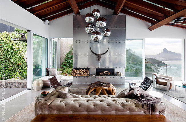 Гостиная. Центральное место здесь занимает каминная зона. Дымоход выложен стальными панелями, а на нем висит бычья голова, привезенная с Бали.