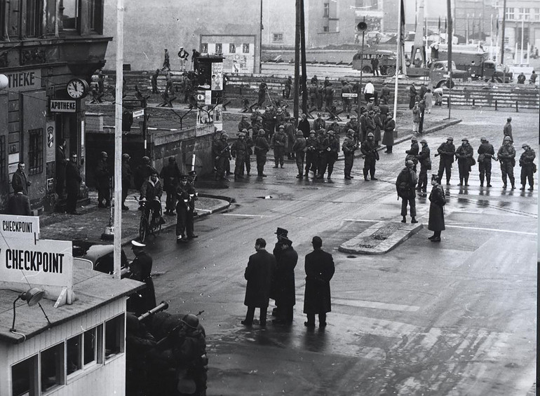 Фридрихштрассе, разделенная пополам Берлинской стеной, 1961 год. За плотным заграждением из боеспособной фольксармии полиция и строители возводят танковый заграждение. Универсальная группа изображений через Getty Images.