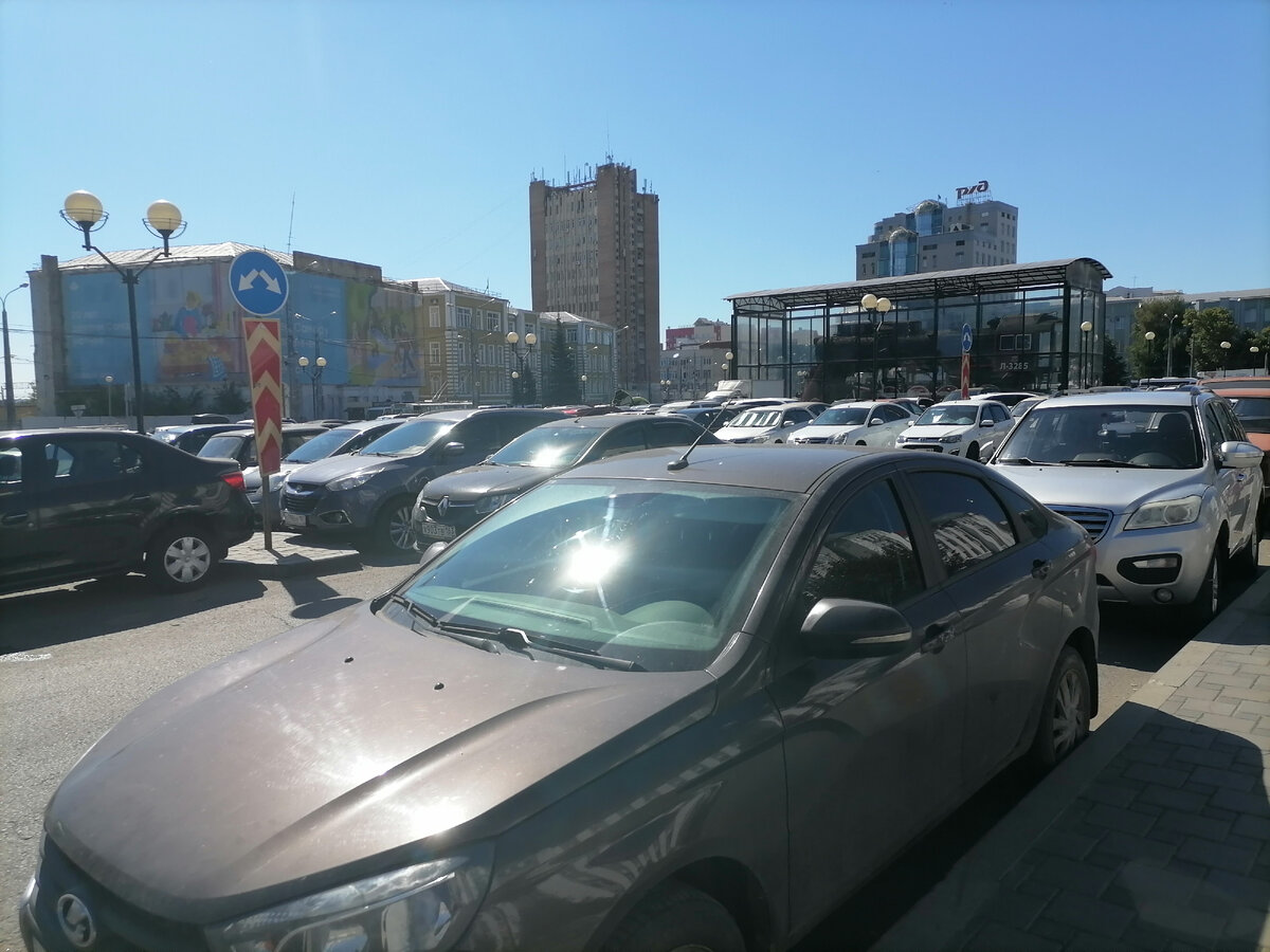 Парковка вокзала и старый паровоз под стеклом