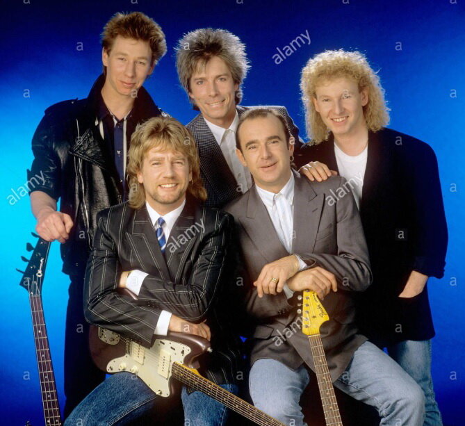 Status Quo, 1988. Слева направо: Джон Эдвардс, Рик Парфитт, Энди Баун, Фрэнсис Росси, Джефф Рич (ссылка на фото: https://www.alamy.com/stock-photo-status-quo-singer-rick-parfitt-und-francis-rossi-on-27051988-in-mnchenmunich-129696592.html)