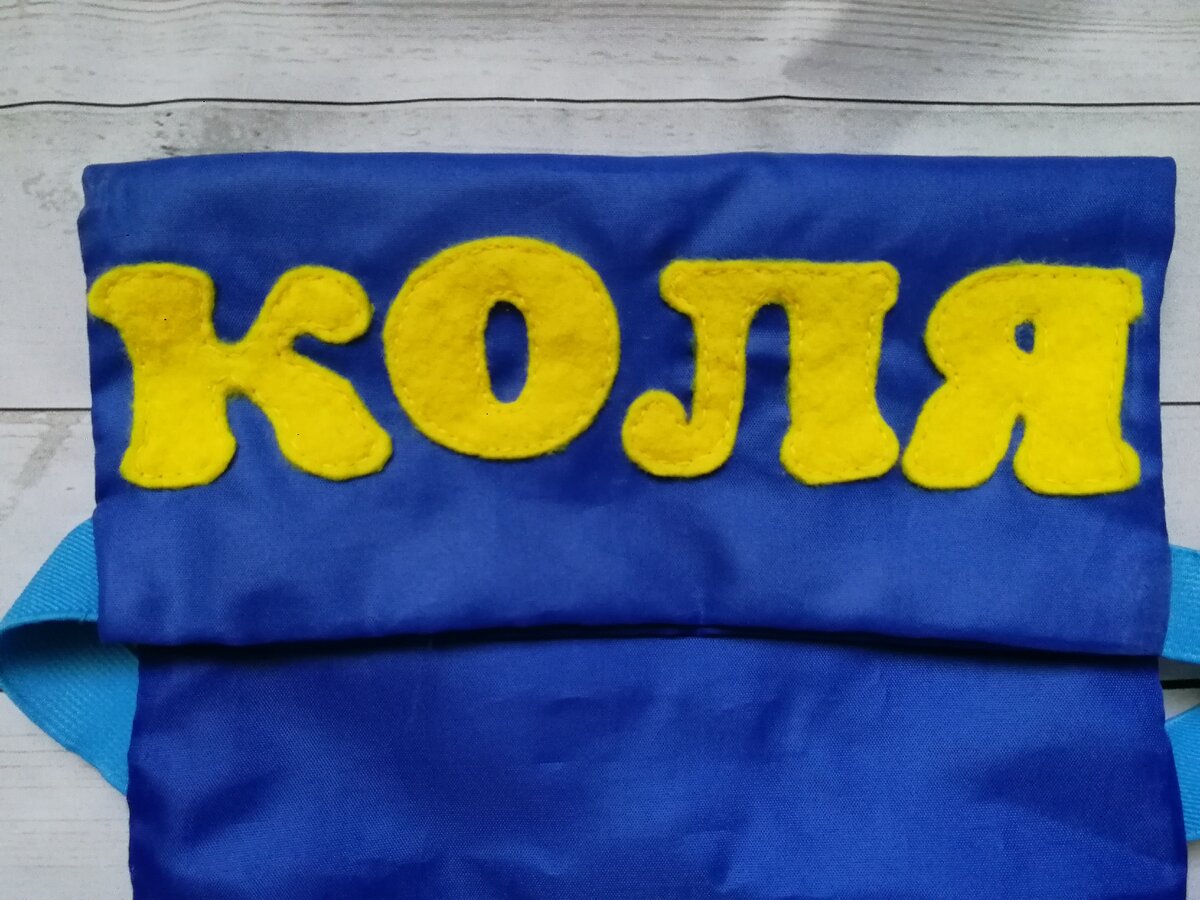 Эта часть свешивается на лицевую сторону шкафичка - ребенок запомнит свое имя. Для того чтобы сделать такой отворот, понадобится либо липучка, либо широкая резинка и прибавить к желаемой высоте кармашков длину отворота для раскроя