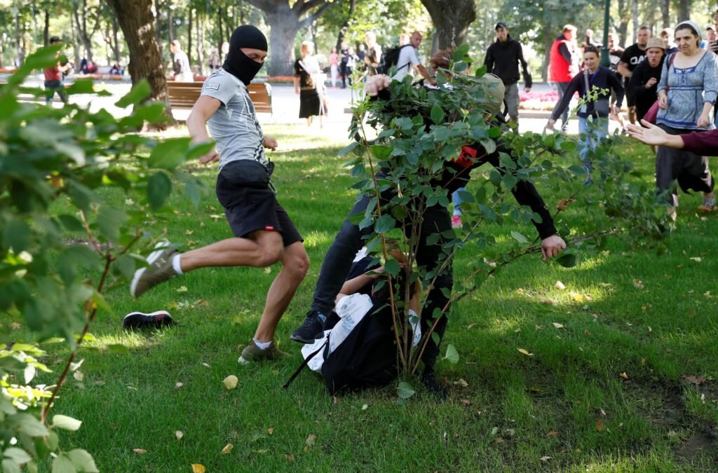  Молодой человек, похожий на скин-хеда избивает ногами участника марша KharkivPride 