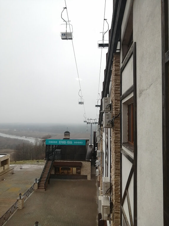 Вид из холла гостиницы. Подъёмник вдоль кровли. А на кровле спуск.