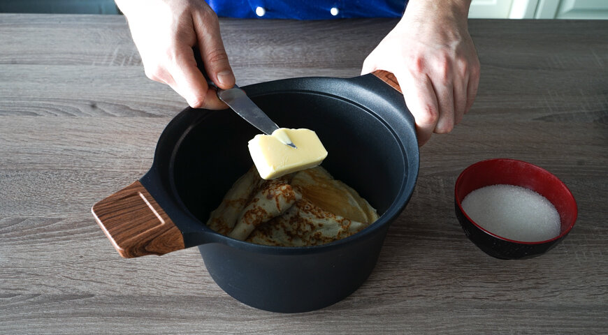 Шаг 1Приготовьте тесто для блинов на кефире с дырочками. Яйца взбейте миксером с обычным и ванильным сахаром до получения пышной массы однородной консистенции.Добавьте водку, соль и еще раз взбейте. Влейте кефир и перемешайте. Муку просейте и, постоянно помешивая, постепенно всыпайте в смесь до тех пор, пока тесто не приобретет консистенцию густой сметаны.Шаг 2Соду насыпьте в мисочку, залейте яблочным уксусом и перемешайте. Добавьте в блинное тесто на кефире. Влейте растительное масло и тщательно перемешайте кулинарной лопаточкой. Оставьте на 20 минут при комнатной температуре.Шаг 3Затем, взбивая блинное тесто на кефире большим венчиком, постепенно, тонкой струйкой влейте кипящую воду. В результате должна получиться масса консистенции жидкой сметаны.Шаг 4Сковороду для жарки блинов нагрейте и смажьте небольшим количеством растительного масла. Влейте немного теста и круговым движением распределите его по всей сковороде. Выпекайте 1,5 минуты. Затем переверните блин и подрумяньте с другой стороны.Шаг 5Таким образом испеките все блины на кефире. Готовые слегка смажьте сливочным маслом, присыпьте сахаром и сложите вчетверо. Поместите в небольшую кастрюлю.Шаг 6Блины на кефире посыпьте оставшимся сахаром и положите сверху около 100 г сливочного масла. Плотно накройте крышкой и поставьте в теплую (нагретую и затем выключенную духовку) на 2 часа. 