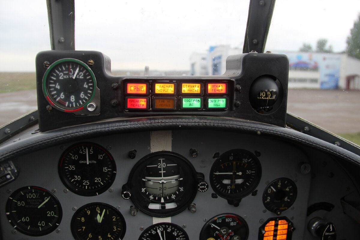 Стрелочный указатель величины ускорения (перегрузки) на самолете Як-52. Левая половина циферблата - отрицательная перегрузка, правая - положительная. Самолет рассчитан на высокие перегрузки, поскольку исполняет фигуры высшего пилотажа. Обратите внимание, что указатель перегрузки корректно показывает на земле единицу.