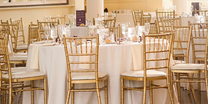 Стулья кьявари отлично смотрятся и безо всяких украшений, здесь золотые стулья со светлыми подушечками по сути играют главную партию в оформлении зала  