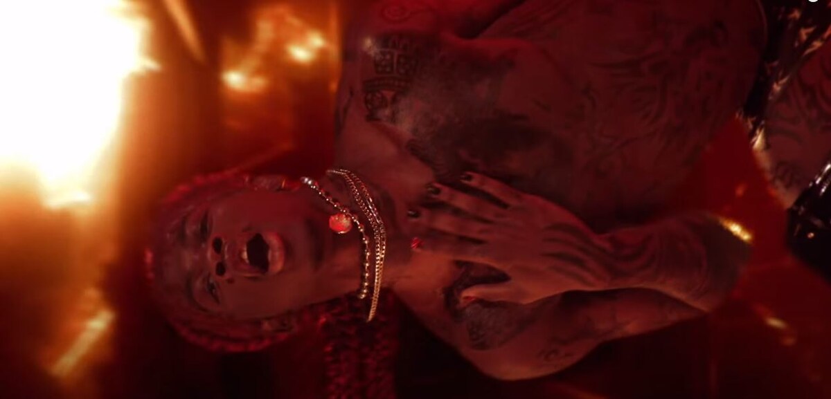 Рэпер в музыкальном клипе изображающий "Сатану", который спускается с небес в ад