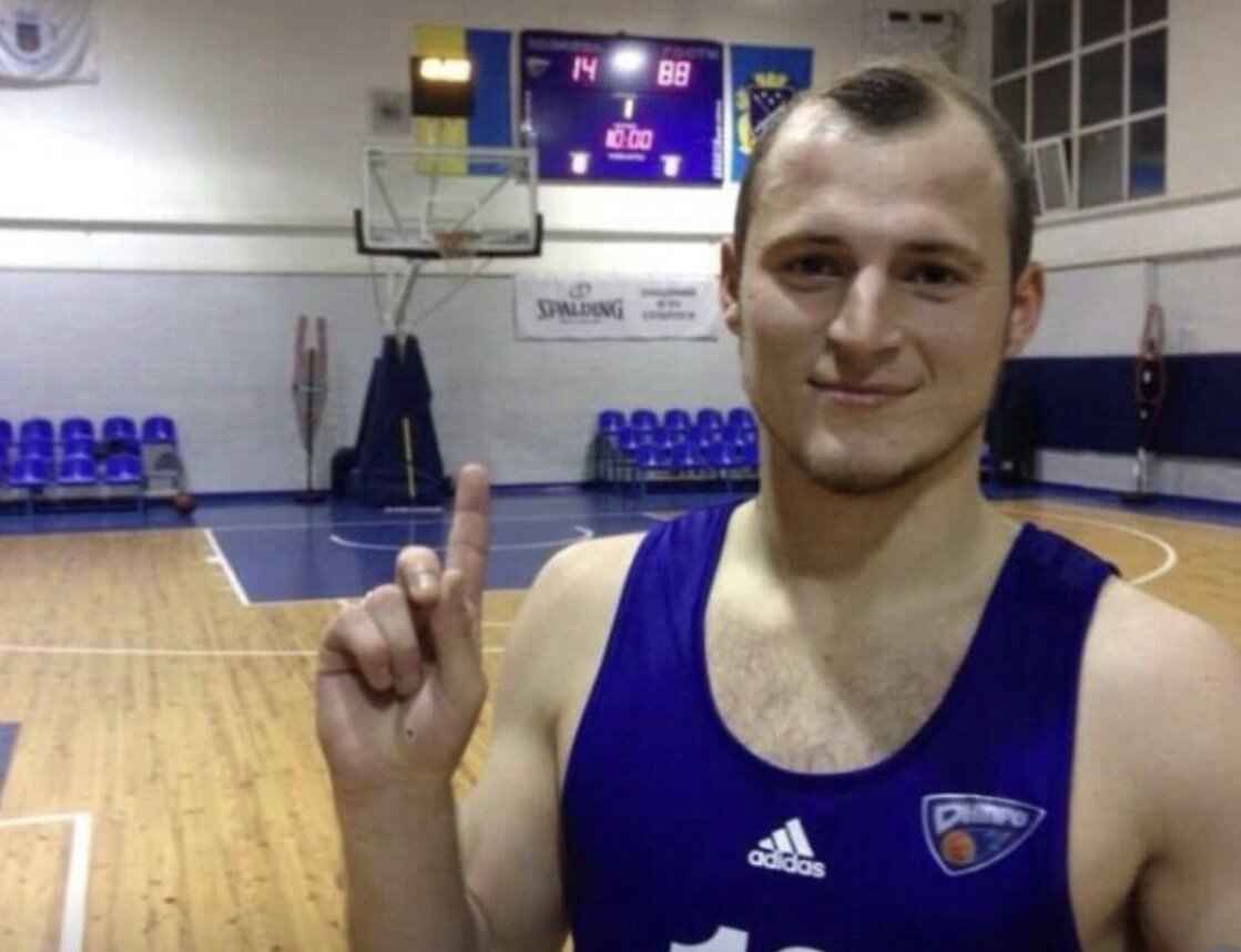 Зозуля в спортивном зале указывает вверх на табло.