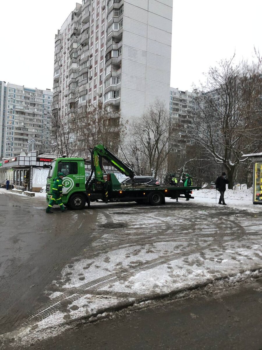 Эвакуатор увозит последние машины с пятачка перед домом 16 корпус 1 в Крылатском ранним утром 31 декабря. 