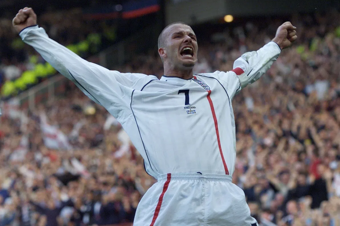 Бекхэм празднует гол со штрафного в ворота Греции. 