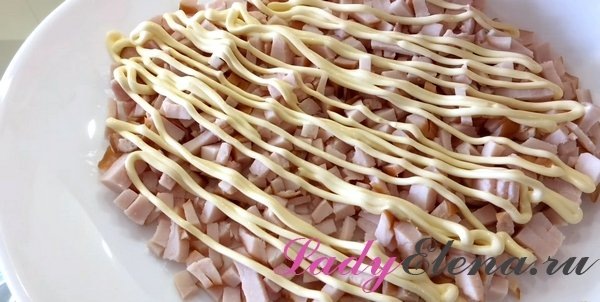 Мелко режем копчёную куриную грудку и выкладываем её на дно тарелки (можно использовать кольцо, чтобы получить более четкую форму). Сверху делаем майонезную сеточку.