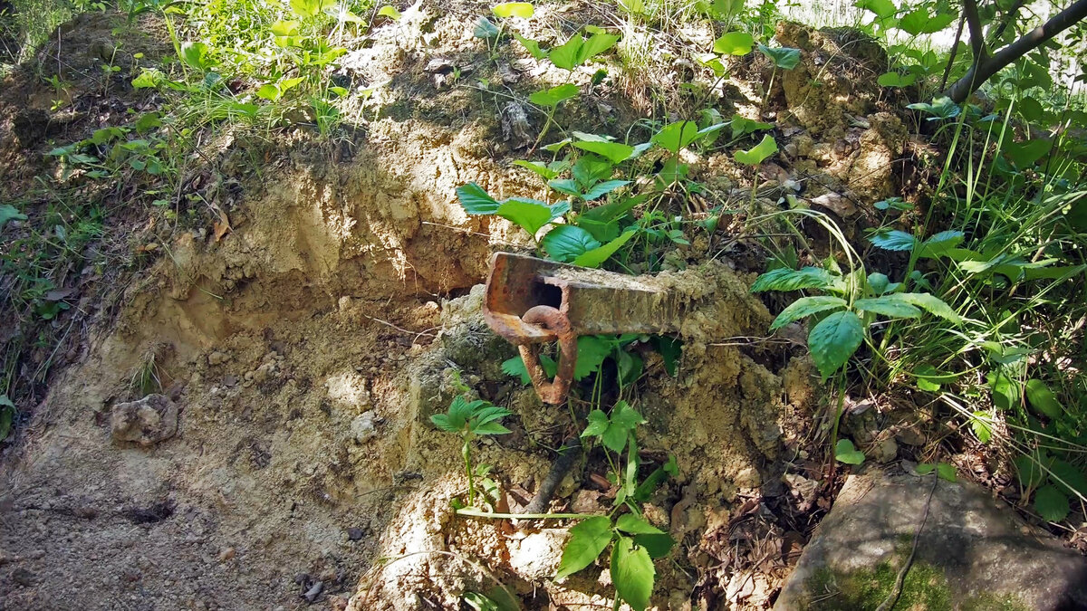 Металл торчащий из-под камня.