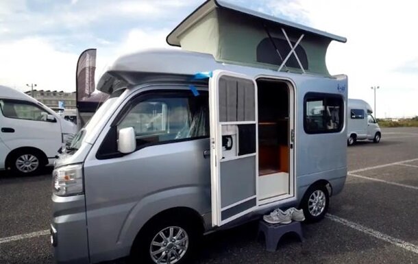 В Японии на выставке домов на колесах был представлен самый компактный жилой автомобиль на планете. Модель AZ-MAX k-ai построена на базе автомобиля Daihatsu Hijet, пишет Motor. 
Несмотря на миниатюрные габариты в доме-авто помещаются четыре человека. В салоне установлен диван, который раскладывается в двуспальную кровать. На втором ярусе располагается выдвижной матрас для двух человек. Есть съемный столик, бак с водой.

Жилое авто оснастили мощной батареей, которая может отапливать салон, не запуская мотор.

Крыша у дома-автомобиля поднимается, что дает возможность находиться там в полный рост среднестатистическому японцу.

Привод у авто дома может быть как передний, так и полный, а объем мотора меньше литра.

Стоит такой дом на колесах чуть более 25 тысяч долларов.