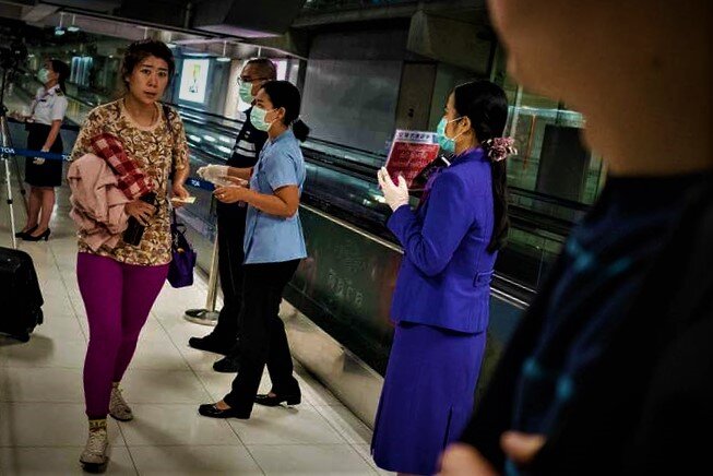 Официальные лица здравоохранения Таиланда раздают информацию о мониторинге заболеваний пассажирам, прибывающим из города Ухань, Китай 
