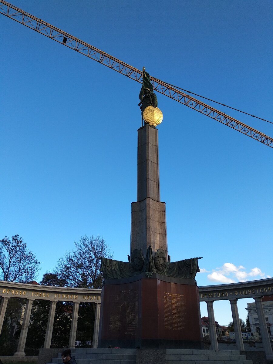 На постаменте возвышается советский солдат со знаменем в одной руке и гербом СССР в другой 