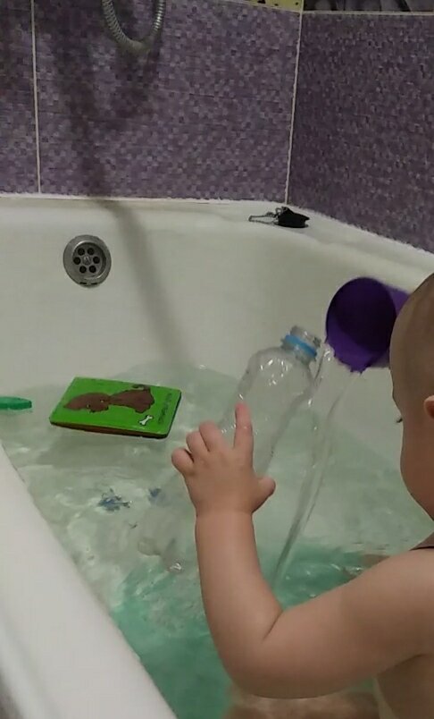 Сынуля переливает воду из стаканчика в бутылку