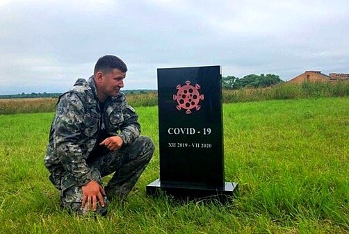 На фото памятник коронавирусу и его создатель