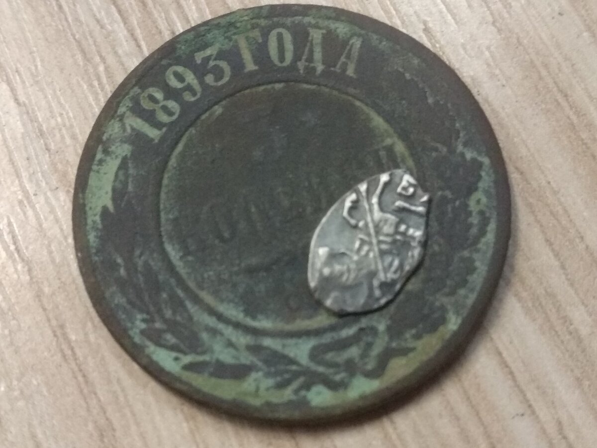 Петровская чешуйка на фоне уставшей трехкопеечной монеты Николая II. 